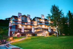Un hôtel à plusieurs étages doté de balcons, d’une pelouse bien entretenue et d’une adresse facilement visible.