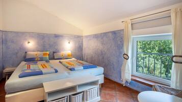 Een slaapkamer met een bed, nachtkastjes, een raam met uitzicht en een balkon.