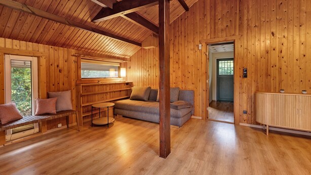 Un interior de madera con sofá, banco y radiador.