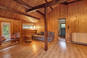 Un intérieur en bois avec un canapé, un banc et un radiateur.