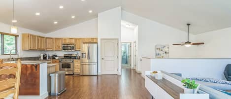 Una cocina amplia con gabinetes de madera, electrodomésticos de acero inoxidable y una isla central.
