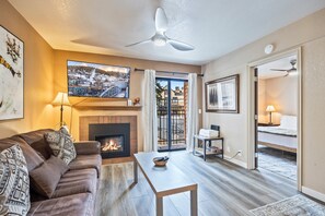 Una sala de estar con chimenea, un sofá, una mesa de centro y un cuadro grande en la pared.