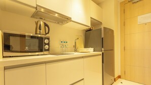 A modern kitchen with stainless steel appliances, including a microwave, kettle, and refrigerator. - Sea View Beach Bar Beach Front c114 (Rawai)