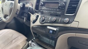 L’intérieur d’une voiture, avec le tableau de bord, une radio, les bouches d’aération et l’écran d’affichage de la caméra de recul.