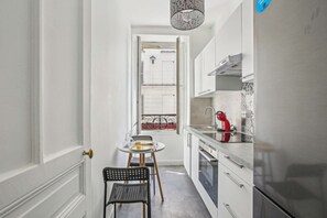 Enjoy meals in this kitchen with an oven, refrigerator, and dining table for two.