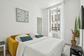 Relax in this serene bedroom with a comfortable bed, a stylish armchair, and a beautiful view from the large window.