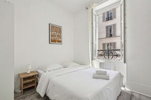 Relax in this serene bedroom with a single bed, a nightstand, and a beautiful view from the large window.