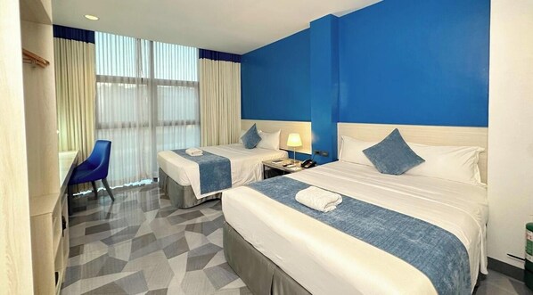 A hotel room with two beds, a desk, and a chair. - Stacia Hotel (Cebu City)