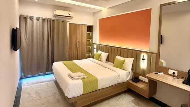 Una moderna camera d'albergo con un letto grande, un comodino e uno specchio.