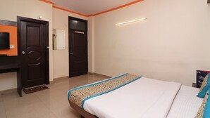 A hotel room with a bed, a desk, and a TV. - Hotel M A International (New Delhi)
