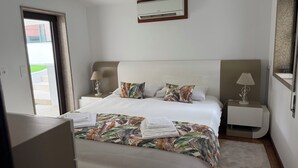 A hotel room with a bed, a nightstand, a lamp, and a wall-mounted air conditioner. - Casa Pinto Douro, your vacation home with a breathtaking view.  (Baiao)