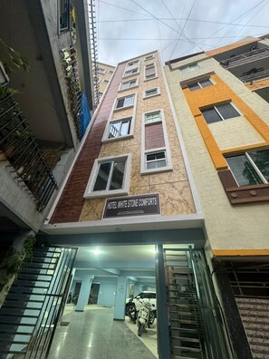 A multi-story building with a sign reading "Hotel White Stone Comforts." - White Stone Apartments (Bengaluru)