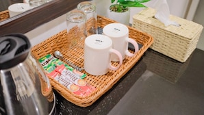 A wicker tray with a coffee maker, two white mugs, tea bags, and a tissue box. - Baan Chinnakarn (Chiang Mai)