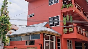 A red building with a sign reading "The Burnt House." - Baan Chinnakarn (Chiang Mai)