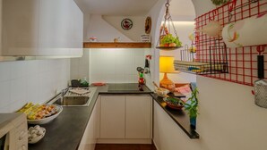 Una cocina con un lavamanos, encimera y varios utensilios de cocina.
