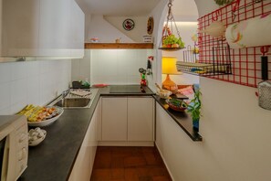 A kitchen with a sink, countertop, and various kitchen items.