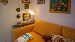 A room with a bed, a lamp, a teddy bear, and a painting on the wall.