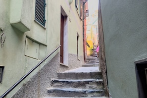 Une ruelle étroite avec un escalier en pierre menant à une porte.