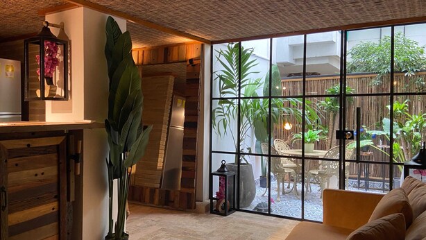 Una sala acogedora con un amplio ventanal, un armario de madera y un sofá.