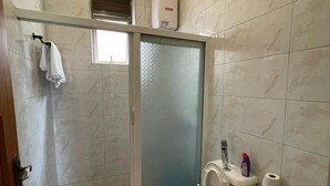 Bany amb dutxa tancada amb vidre, vàter i rentapel.