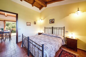Un dormitorio con cama, mesitas de noche y ventana.