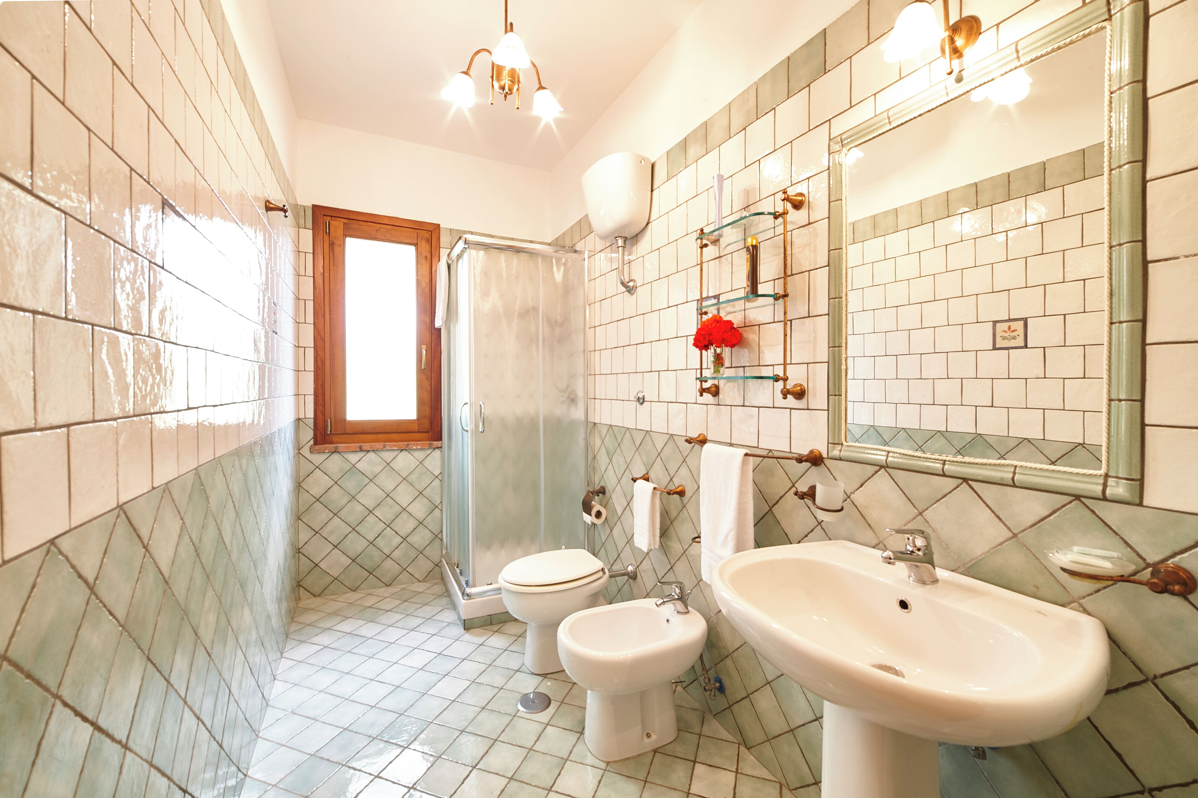 Une salle de bain équipée d’une douche, de toilettes, d’un bidet et d’un lavabo.