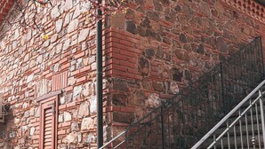 Un edificio de piedra con escaleras de ladrillo y barandilla de metal.