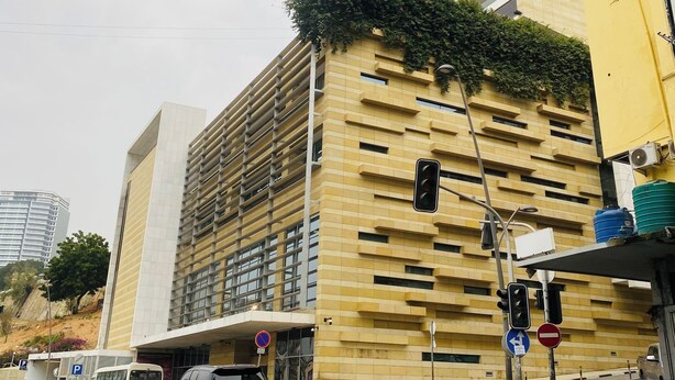 A modern building with a yellow facade and a large window. - Aconchegante Apartamento na Marginal de Luanda, Para uma Estadia Confortável (Luanda)
