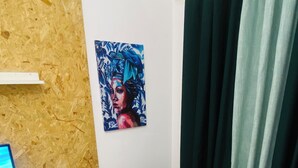 A room with a white table, green chairs, a painting on the wall, and a window with curtains. - Aconchegante Apartamento na Marginal de Luanda, Para uma Estadia Confortável (Luanda)