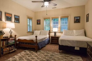 A bedroom with two single beds, a ceiling fan, a bookshelf, and framed pictures on the walls. - Scenic 2BR Condo w/ Porch + Pool Near Slope/Trails | Free Tickets (Maggie Valley)