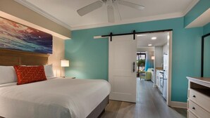 A hotel room with a bed, a ceiling fan, a door leading to a balcony, and a view of the outside. - Resort View Two Room Condo Family-Friendly (Myrtle Beach)