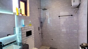 A modern bathroom with a glass shower enclosure, a white toilet, and a marble sink. - Starlight Homes (Kampala)