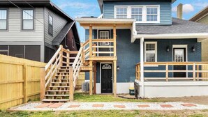 A two-story house with a front porch, a wooden staircase, and a garage. - Spacious unit near Downtown and Bourbon Trail! (Louisville)