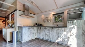 A modern kitchen with a central island, stainless steel appliances, and a window providing natural light. - 3 bedroom amazing home in Heinkenszand (Heinkenszand)