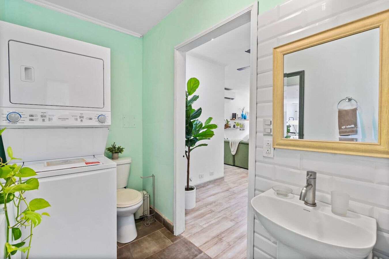 A modern bathroom with a built-in washing machine, toilet, and sink.