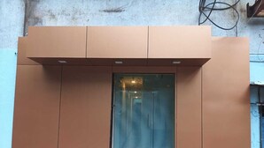 A modern building entrance with a glass door and a metal frame. - Parel Residency (Mumbai)