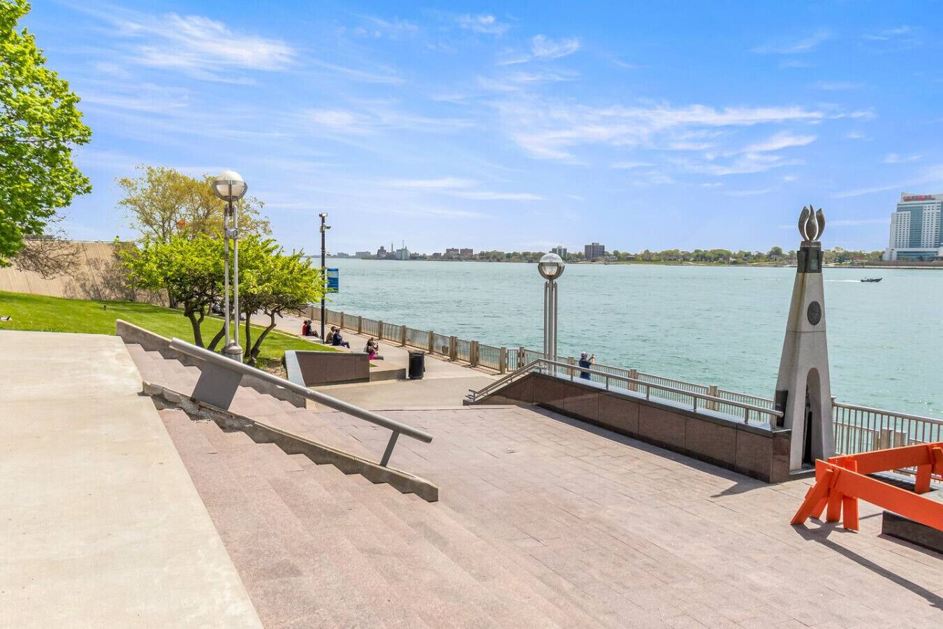 Une promenade en bord de mer, avec des marches menant à une plateforme d’observation, un lampadaire et un monument décoratif.