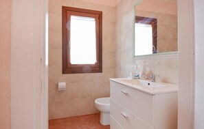 A bathroom with a toilet, a sink, and a mirror. - Beautiful apartment in Vignola Mare with WiFi (Vignola Mare)