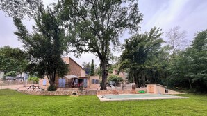 A stone house with a patio, a swimming pool, and a grassy yard. - Charming provençal farmhouse with swimming pool, in the countryside by the river (Le Thoronet)