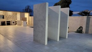 An outdoor area with a tiled floor, a washing machine, and a hose reel. - Apulia Sea Punta Prosciutto (Punta Prosciutto)