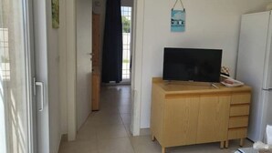 A room with a wooden cabinet, a television, and a refrigerator. - Apulia Sea Punta Prosciutto (Punta Prosciutto)