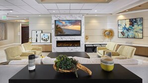 Een moderne woonkamer met een grote televisie, een open haard en comfortabele zitplaatsen.