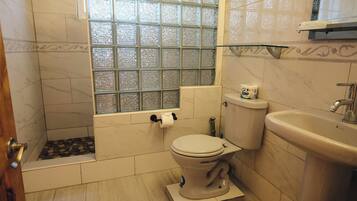 A bathroom with a toilet, sink, and bathtub.