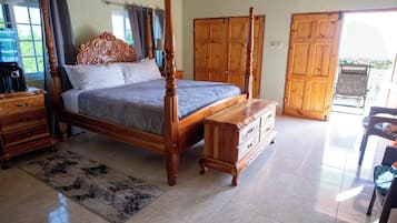 Un dormitorio amplio con una cama grande, un armario de madera y un pequeño escritorio.