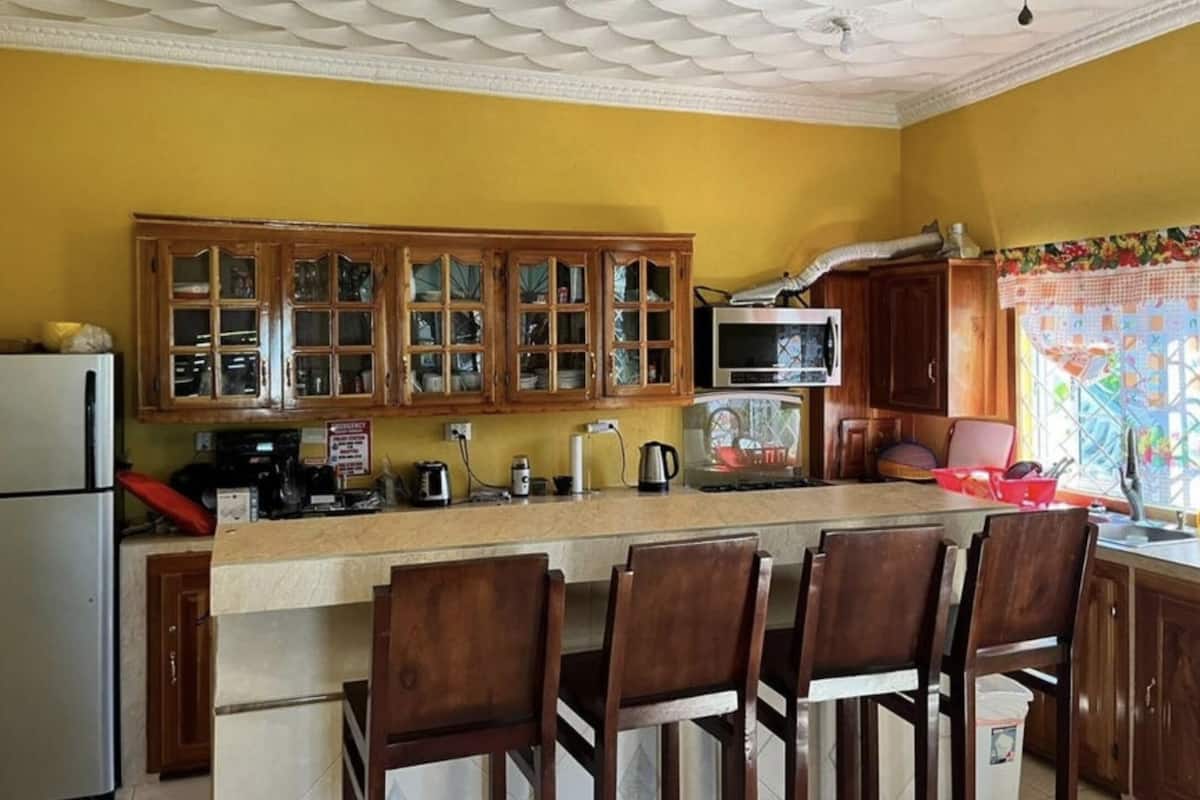 A kitchen with wooden cabinets, a microwave, and a refrigerator.