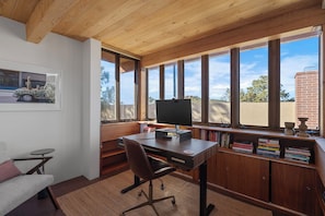 Enjoy a peaceful retreat with a desk for work and a sofa for relaxation, offering a view of the outdoors.