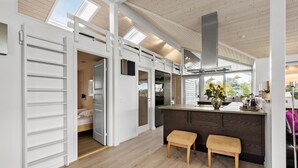 Una cocina moderna con una isla central, suelo de madera y un tragaluz.