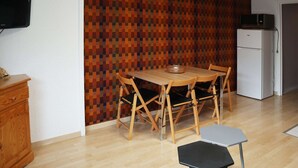 A compact kitchen with a wooden dining table, four chairs, a small refrigerator, and a television on the wall. - Ski-in/ski-out studio, Les Orres 1650 center, 4 people (Les Orres)