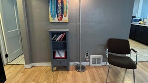 A living room with a bookshelf, a floor lamp, a chair, and a rug.