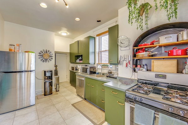 A modern kitchen with stainless steel appliances, green cabinets, and a built-in oven. - Dog-friendly Pittsburgh Home, 3 Mi to Downtown! (Pittsburgh)